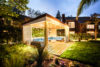 Close up of cabana, surrounded by grass and lush plants and trees.