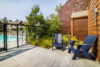 Outside setting blue chairs and coffee table green leafy plants and small decorative trees.