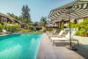 Sunny swimming pool with sun loungers and umbrellas