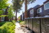 Lockable mailboxes, between 2 story apartment buildings and old growth redwood trees.