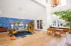 High white ceiling lounge seating with glass coffee table and large blue art wall.